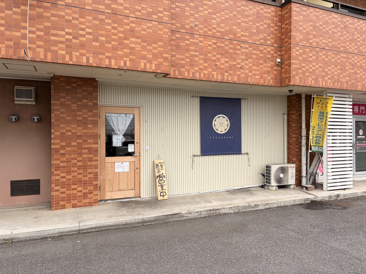 ラーメン店NAGASHARI（筑西市玉戸）の店外観。紺色の暖簾と「一生懸命 営業中」の看板