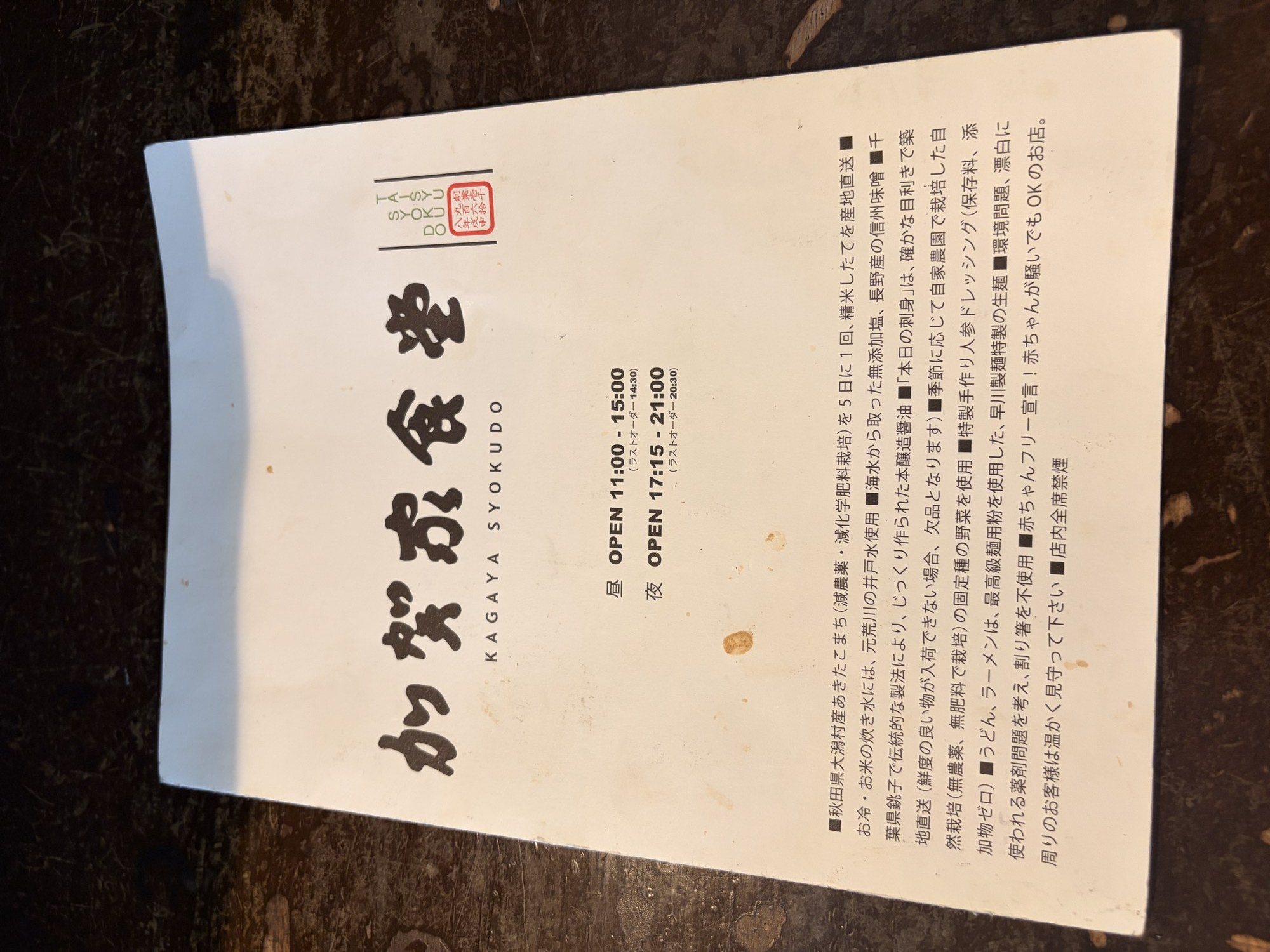 加賀家食堂のメニュー表紙。営業時間と産地直送米・井戸水・築地直送刺身などのこだわり一覧