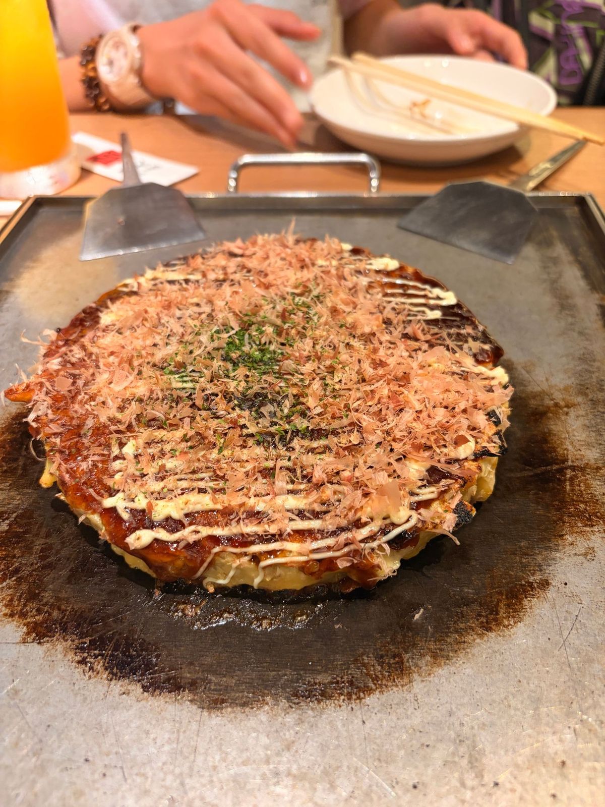 鉄板の上に載ったかつお節たっぷりのお好み焼き