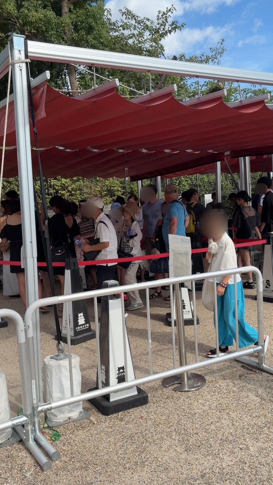 大阪城天守閣の当日券の列。赤いテントの下に並ぶ人たち
