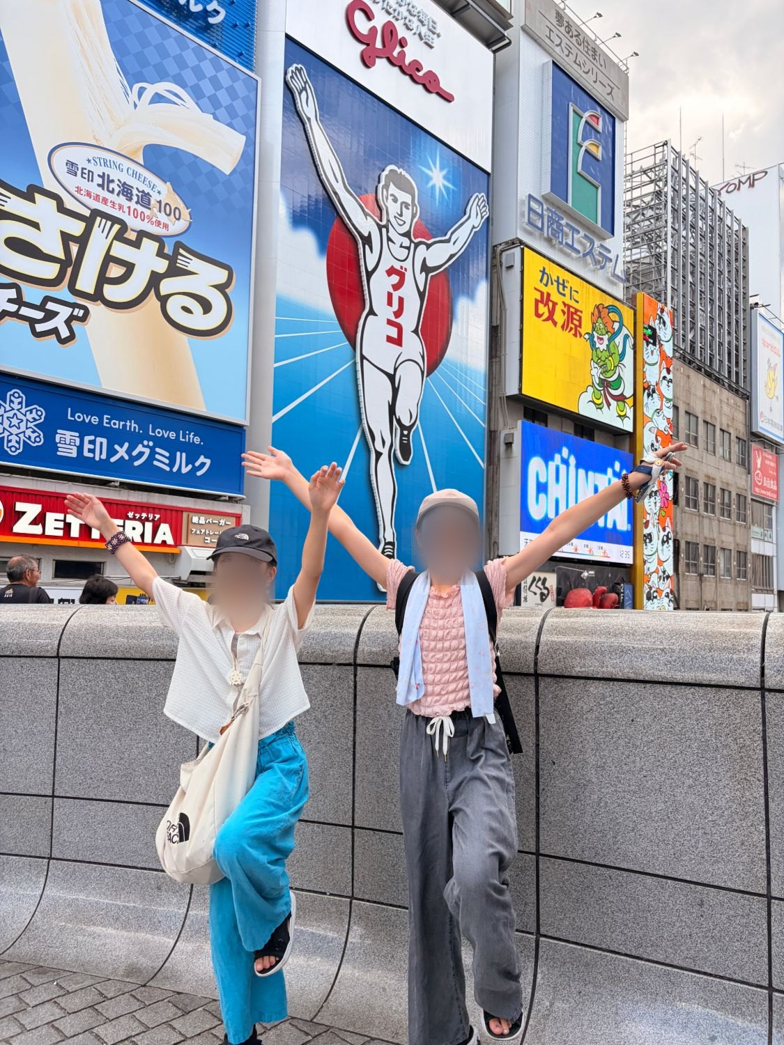 戎橋のグリコサイン前でポーズをとる子どもたち
