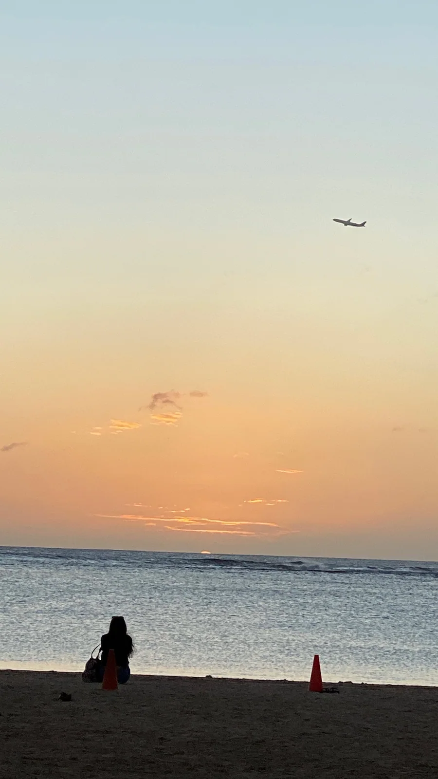 夕日の浜に座る人のシルエット