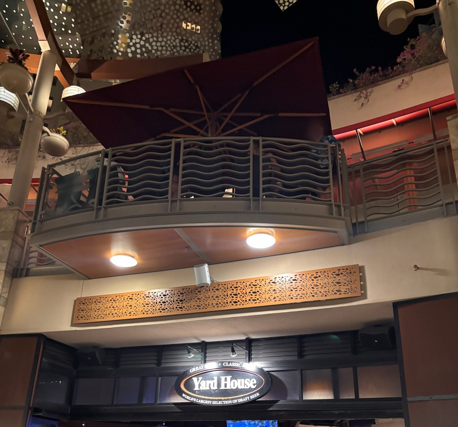 ワイキキ・ビーチウォークのヤードハウスの看板（上のテラスは2階の別店舗）