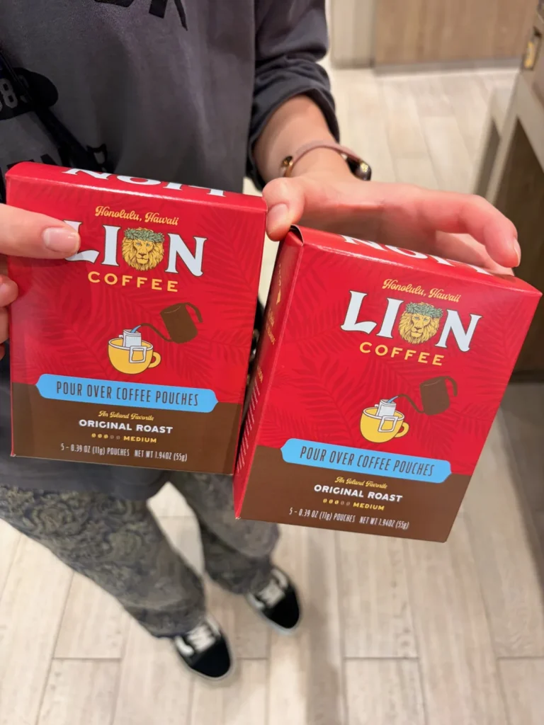ライオンコーヒーのドリップバッグの箱を2つ持つ手