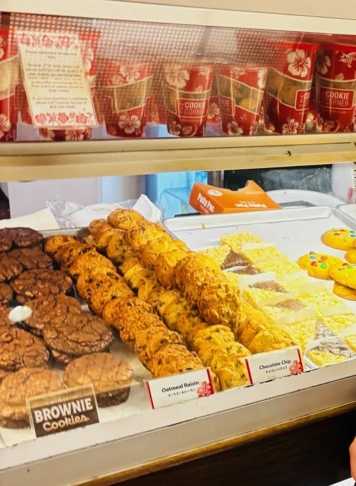 クッキーコーナーのショーケースに並ぶブラウニー、オートミールレーズン、チョコチップのクッキーと赤い缶のお土産
