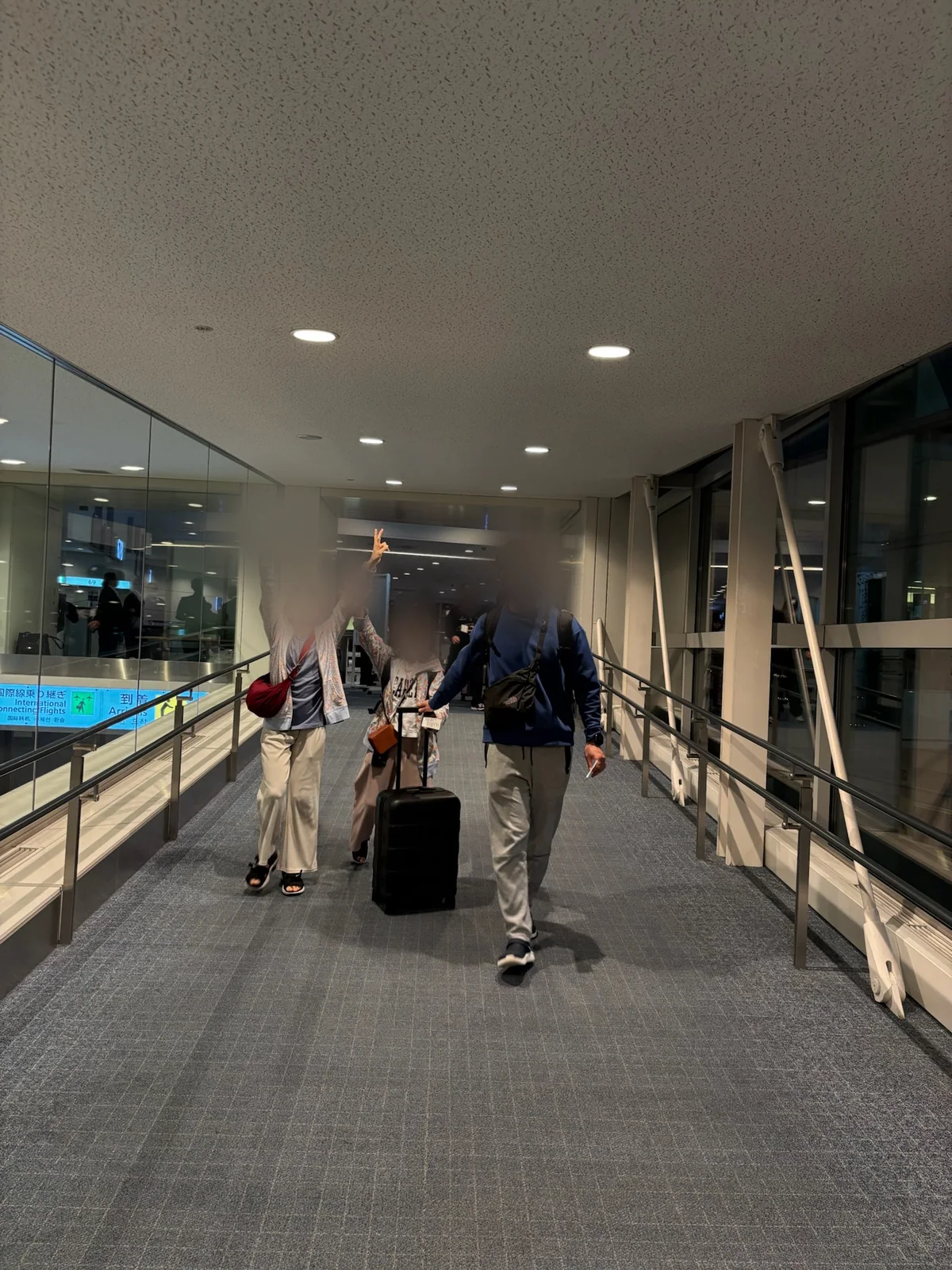 羽田空港の搭乗橋を歩く家族